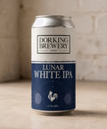 Dorking Brewery Lunar White IPA can on a wooden surface with a brick wall background