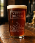 Pint of Dorking Brewery beer on a wooden surface with blurred background