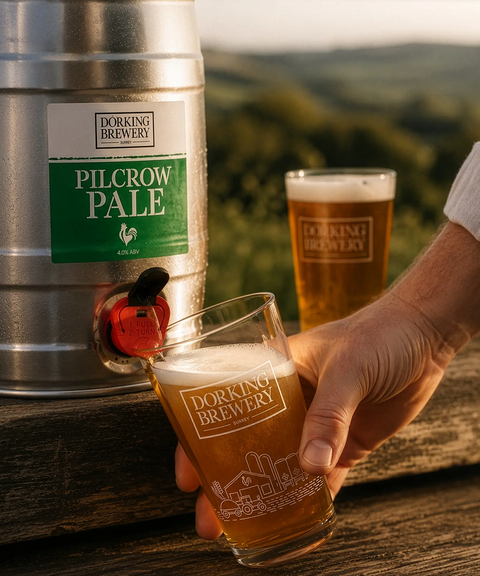 Dorking Brewery Pilcrow Pale beer being poured into a glass with a scenic background.