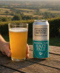 Dorking Brewery Hazy Pale Ale can and glass with a scenic background