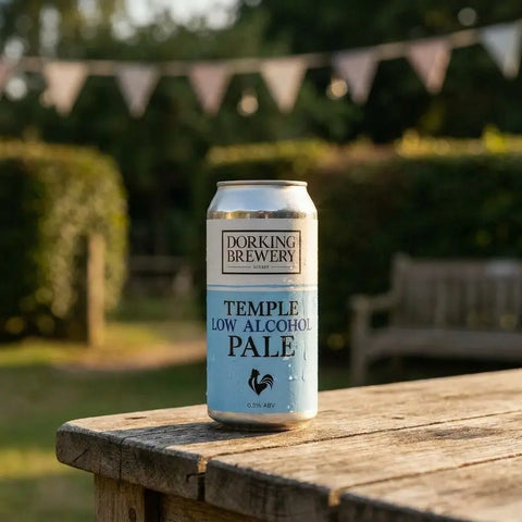A can of Dorking Brewery Temple Low Alcohol Pale on a garden table with bunting behind.